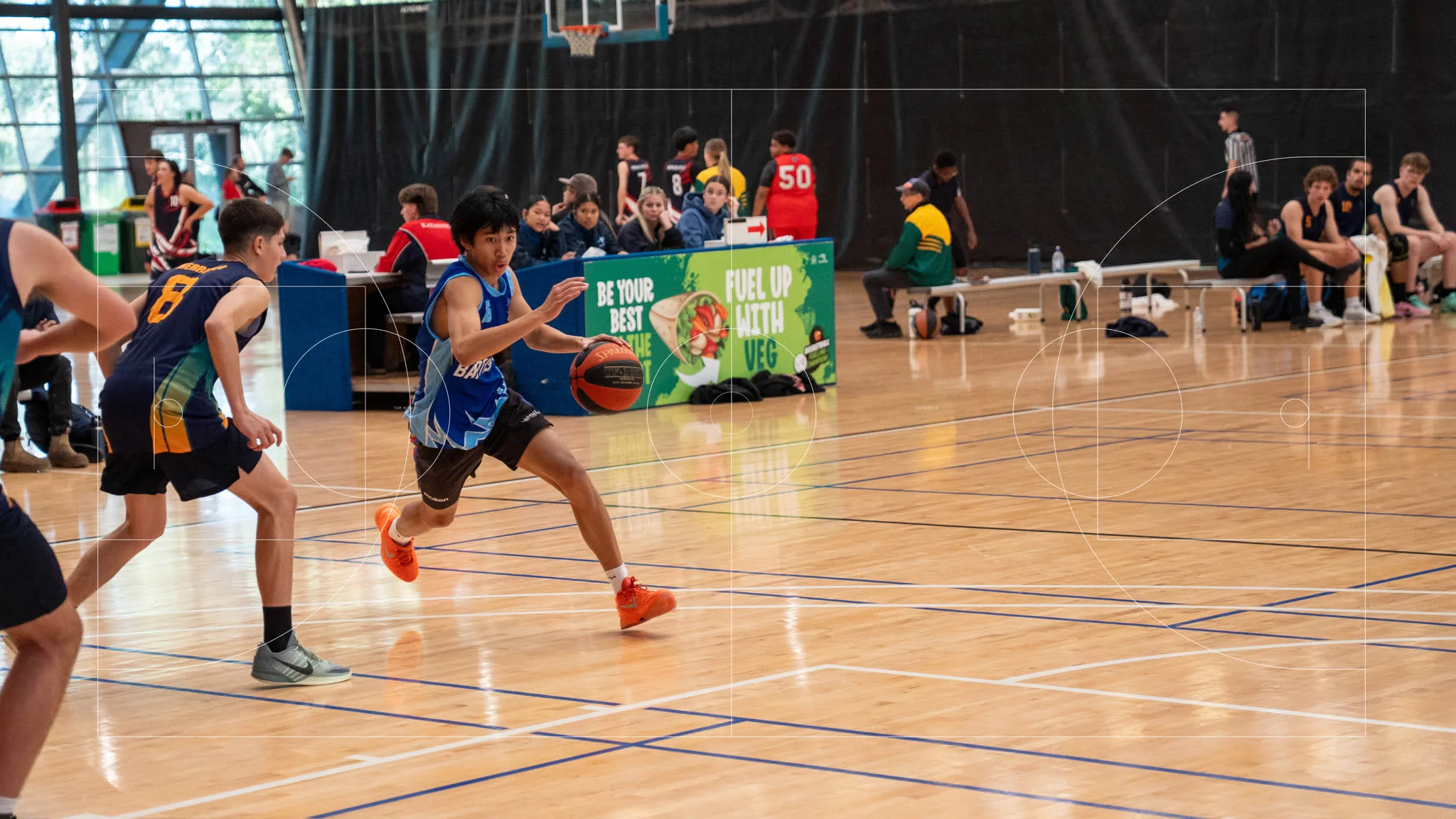 A Bunbury Baptist College student driving to the basket in a competitive basketball match